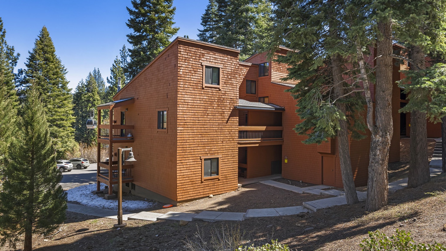 A warm wooden mountain lodge nestled among towering pines, offering the perfect alpine retreat.