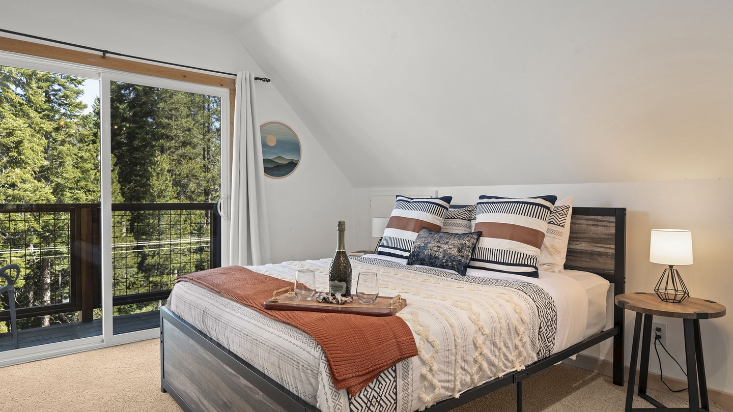 Wake up to lush forest and lake views from your private balcony in this serene bedroom retreat with modern comfort.