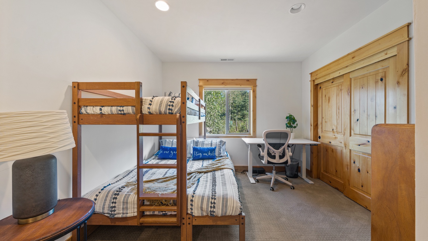 Your spacious room with warm wood furnishings and vaulted ceilings offers flexible sleeping with bunk beds and twin arrangements, plus a dedicated desk for work or planning adventures.