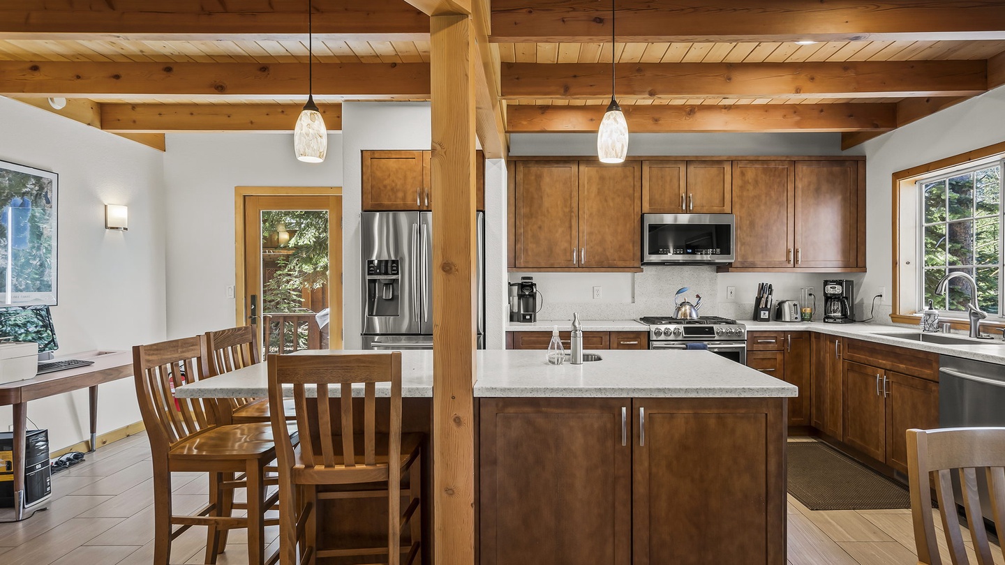 Gather around the spacious kitchen island beneath soaring timber beams, with modern appliances and natural light streaming through the windows inviting you to prepare memorable meals together.