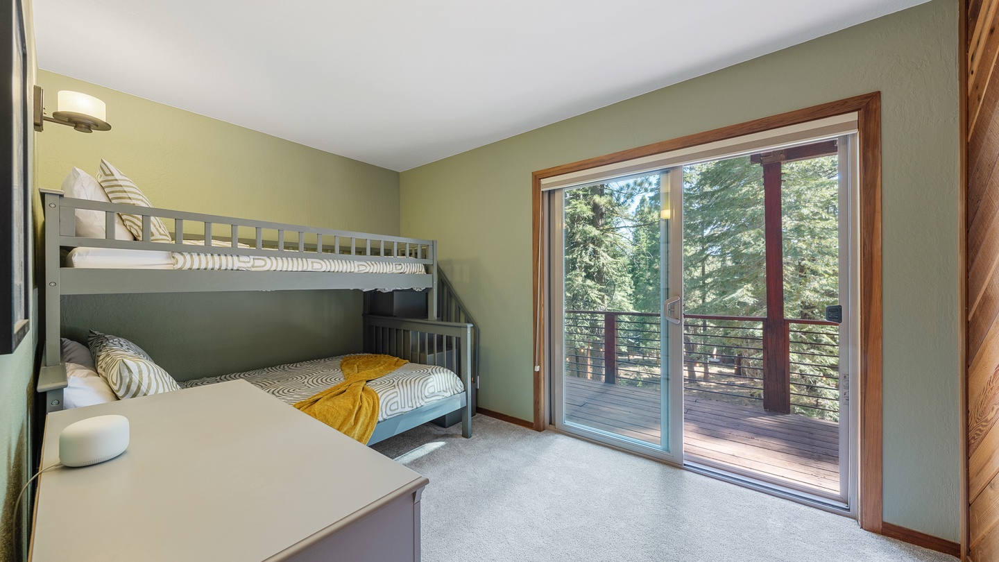 Your kids will love bunking down in this cheerful room, with a large glass door opening to a spacious deck surrounded by towering evergreens.