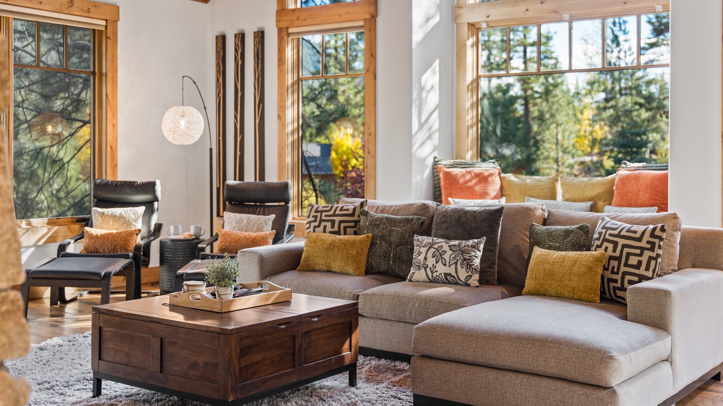 Sink into plush seating surrounded by soaring windows that frame stunning forest views. Warm wood accents and stylish decor create a cozy yet elegant retreat for you to unwind.