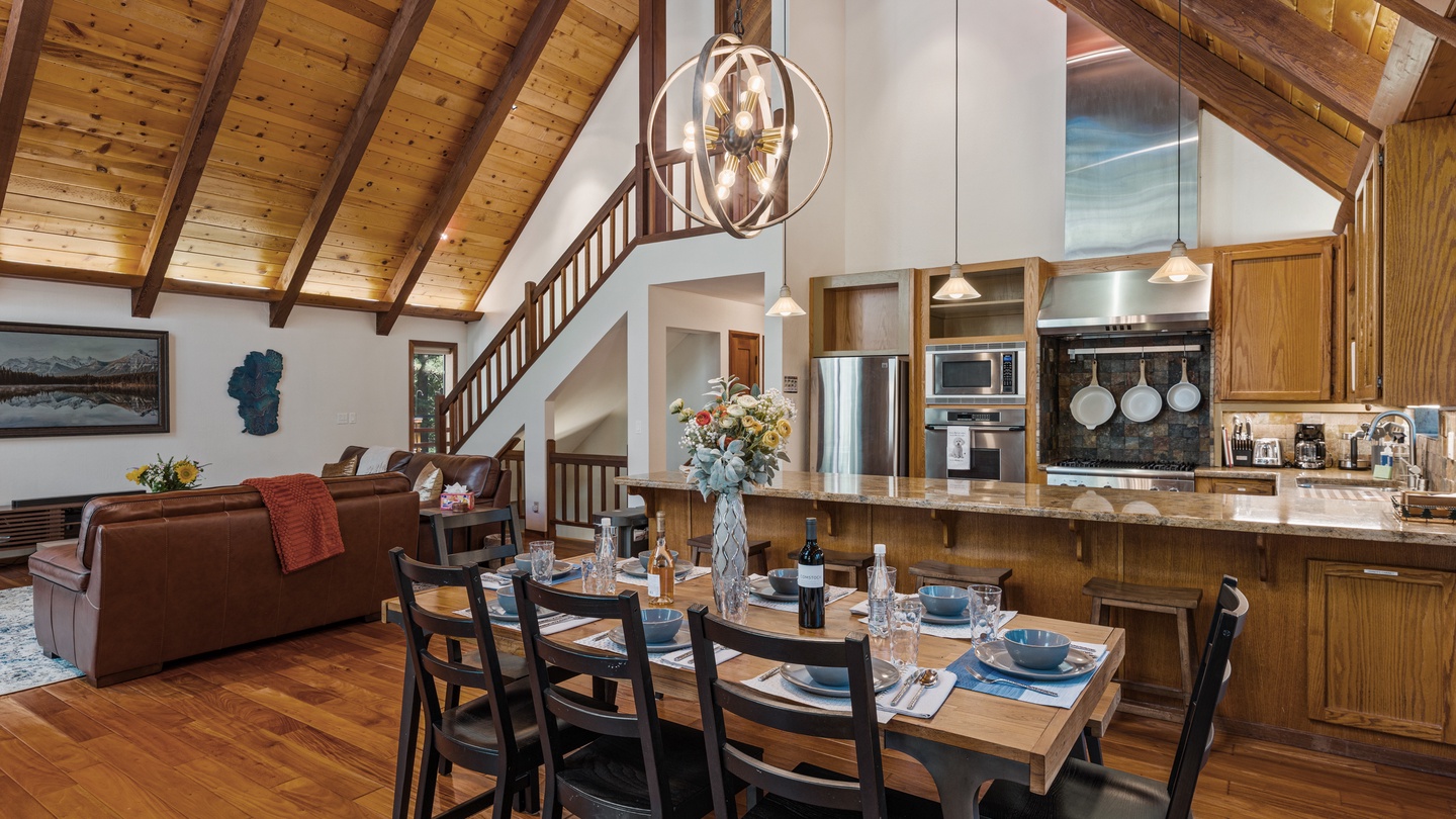 Gather around the dining table under soaring wood-beam ceilings, where the open-concept kitchen invites you to cook together and the cozy living area beckons for relaxed evenings at home.