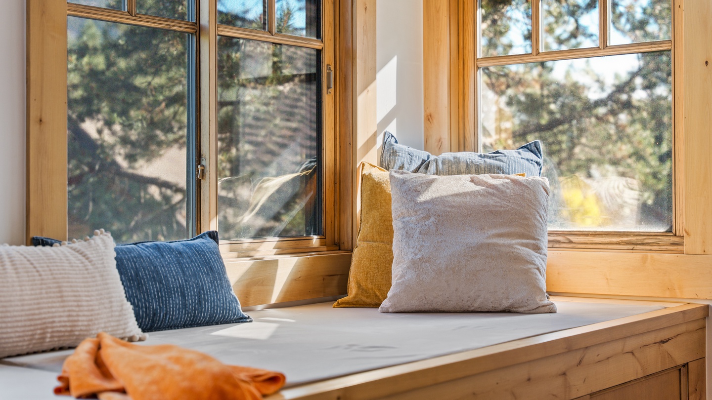 Curl up in your sunny window nook with a book and watch the pines sway—this cozy spot is perfect for lazy mornings or afternoon daydreams.