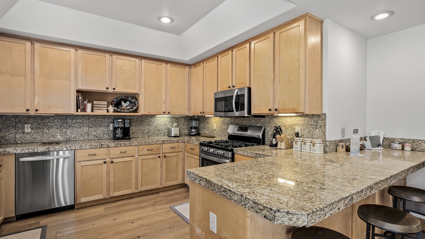 Picture yourself preparing delicious meals in this spacious, fully equipped kitchen with gleaming granite counters, modern appliances, and an inviting island for casual dining and conversation.