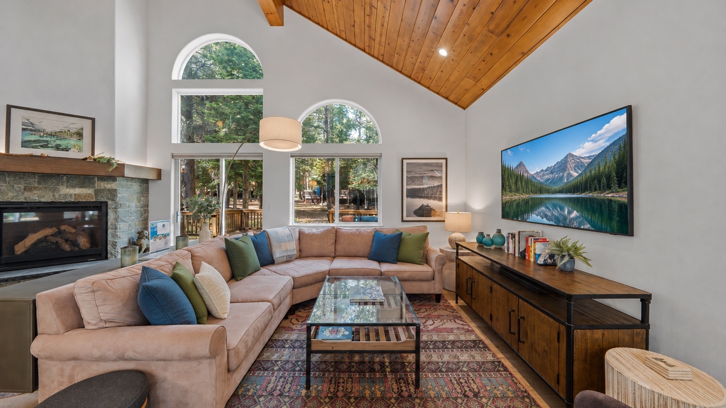 Sink into plush seating beneath soaring wood ceilings and natural light streaming through arched windows. Your cozy fireplace and entertainment center await for mountain evenings in.