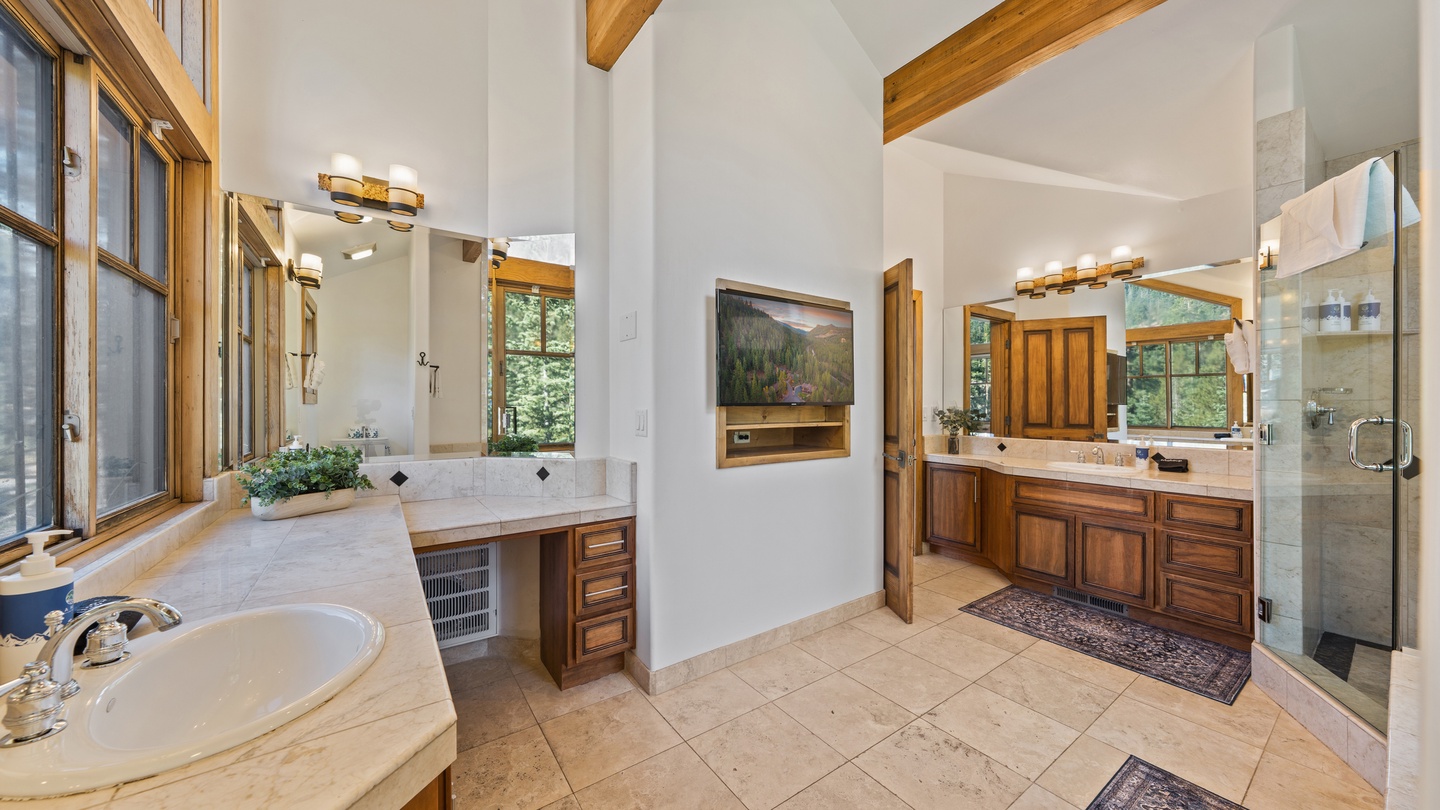 Step into your spacious ensuite retreat with vaulted ceilings, warm wood beams, and elegant dual vanities. Natural light pours in, and your walk-in shower awaits for a refreshing start or relaxing end to your mountain day.