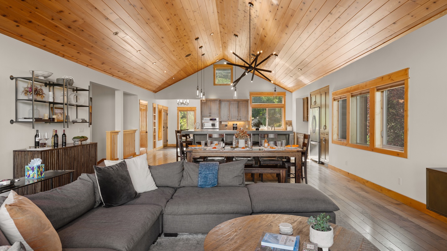 Settle into your spacious open-concept retreat, where soaring wood-plank ceilings and natural light create a warm, airy haven perfect for gathering with loved ones.
