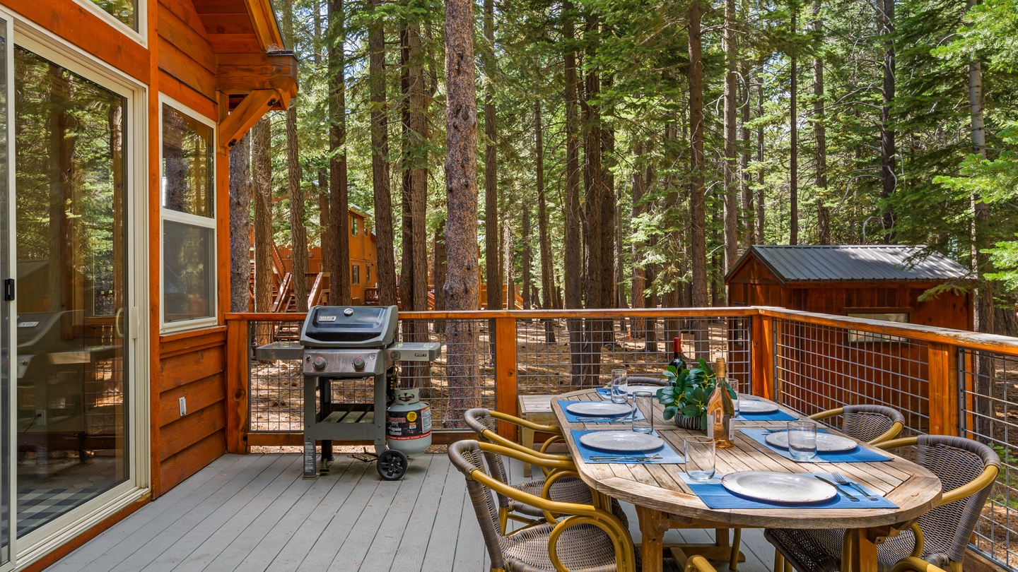 A secluded forest retreat awaits your dining moments on this spacious deck, where tall pines create a serene canopy and the grill stands ready for your cookout. Surrounded by nature, you'll savor meals in complete tranquility.