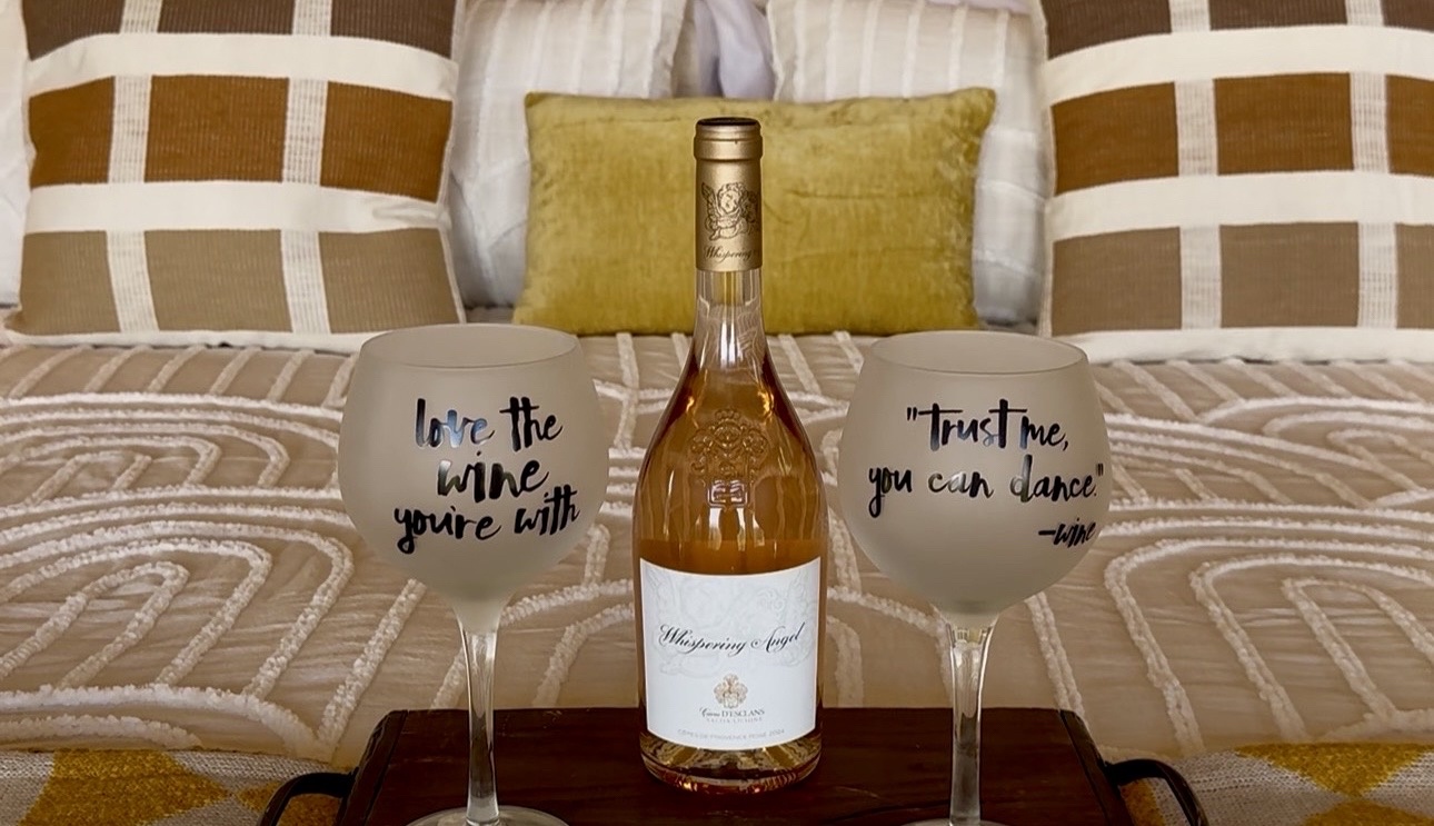 A bottle of wine and two fun glasses await you on the bed—your perfect welcome to relaxation mode.