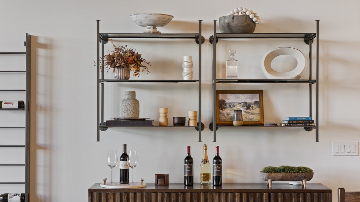 Your stylish bar area awaits—beautifully curated shelving displays elegant glassware and decor, while the sideboard below invites you to pour a glass and unwind in sophisticated comfort.