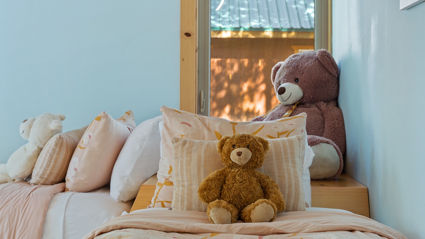 Your kids will adore this charming bedroom, where soft bedding and friendly teddy bears create a cozy haven just for them.