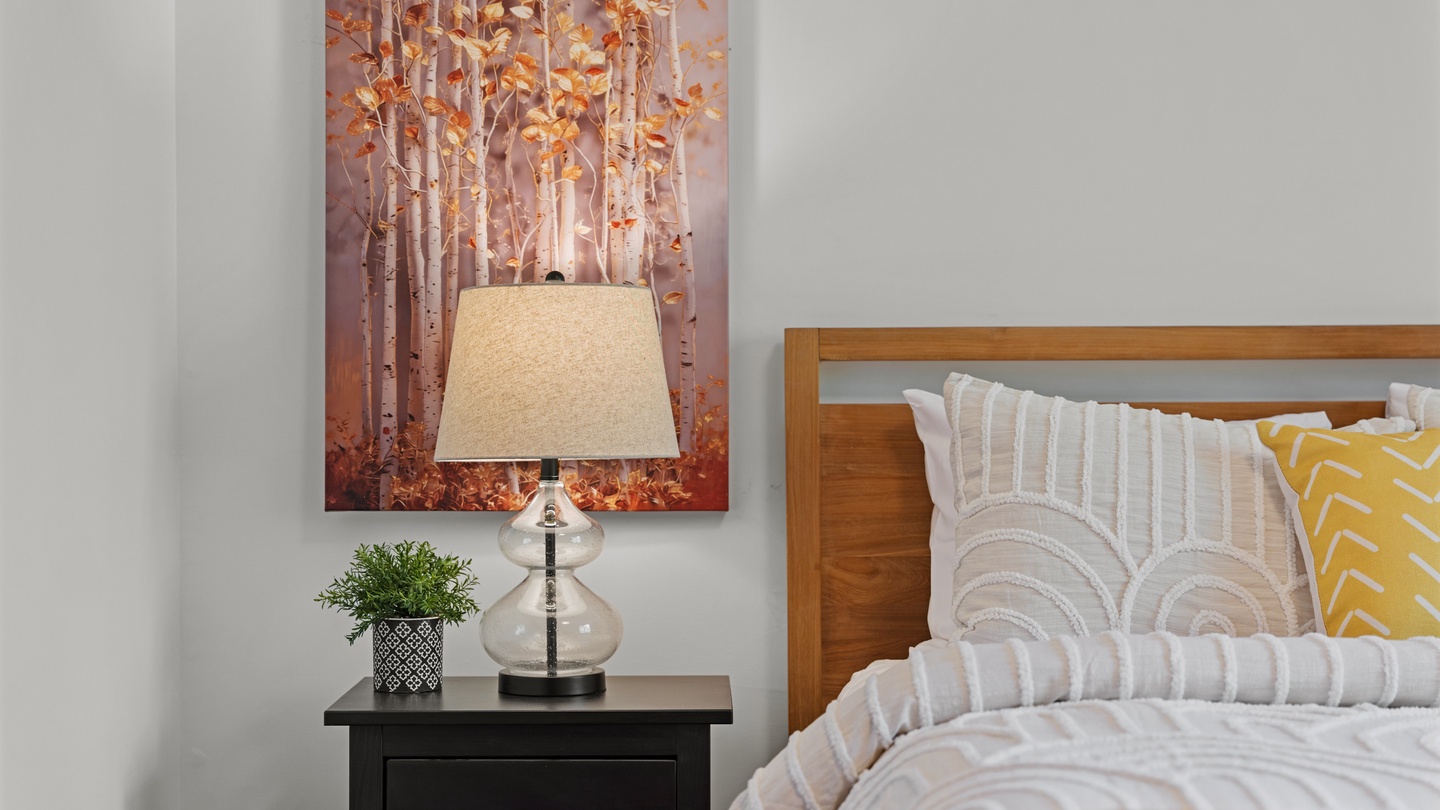 Sink into crisp linens and plump pillows after exploring your surroundings. This cozy bedroom balances warm wood tones with cheerful accents to create your personal retreat.