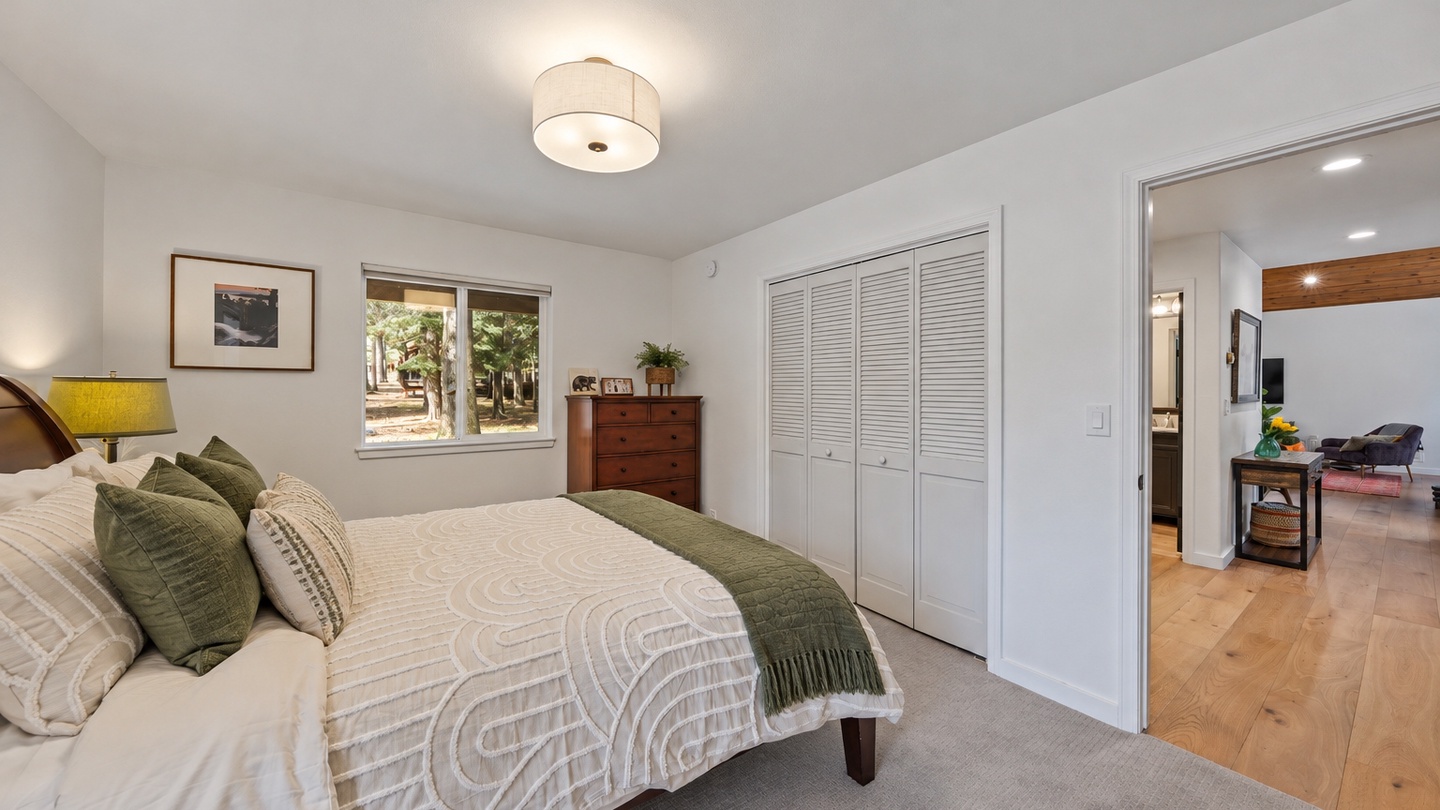 Unwind in your serene bedroom, dressed in calming earth tones and plush textures. A woodland view through the window brings the outdoors in, while generous closet space keeps everything organized.
