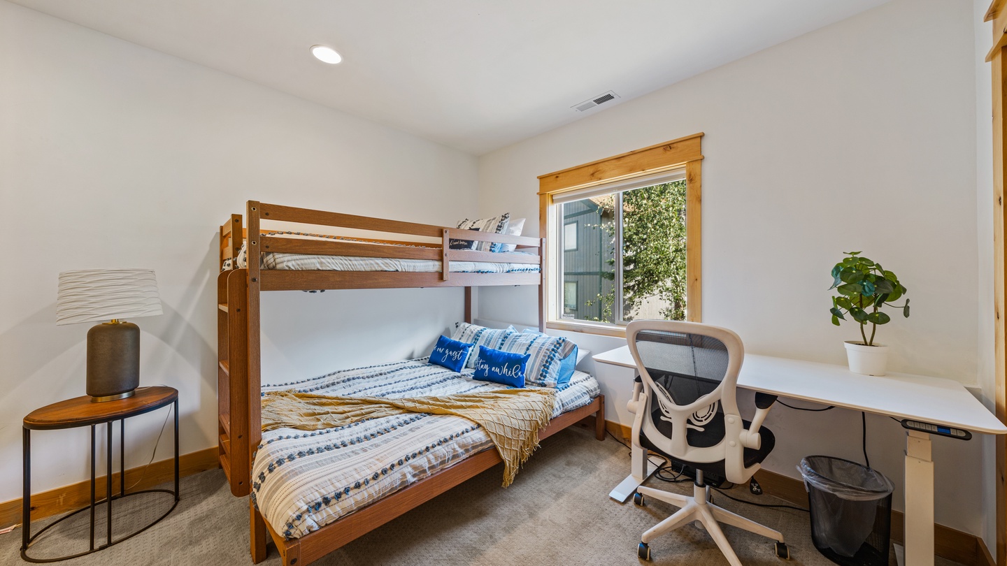 Your kids will love bunking together in this cheerful room, complete with a workspace for homework or creative projects. Natural light pours in through the window, while fresh linens and cozy touches make bedtime a breeze.