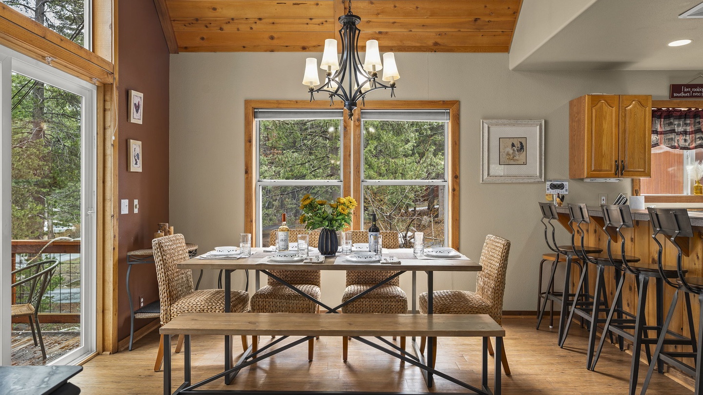 Gather around this inviting dining table where natural light streams through floor-to-ceiling windows, creating the perfect spot for memorable meals together.