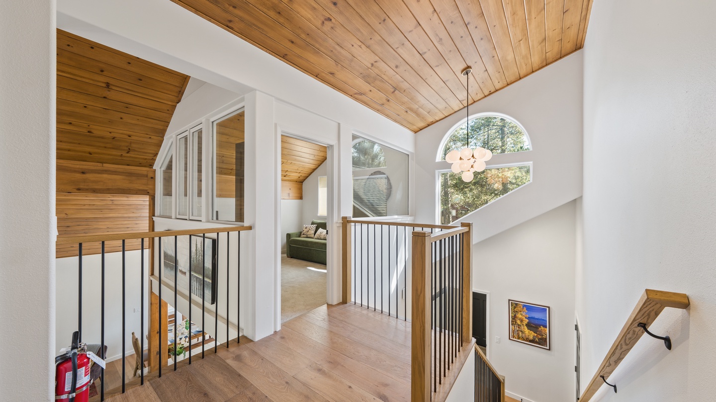 Light floods through arched windows into this second-floor landing, where warm wood ceilings and soft tones create a welcoming moment of calm between rooms. Your retreat feels open, bright, and effortlessly inviting.