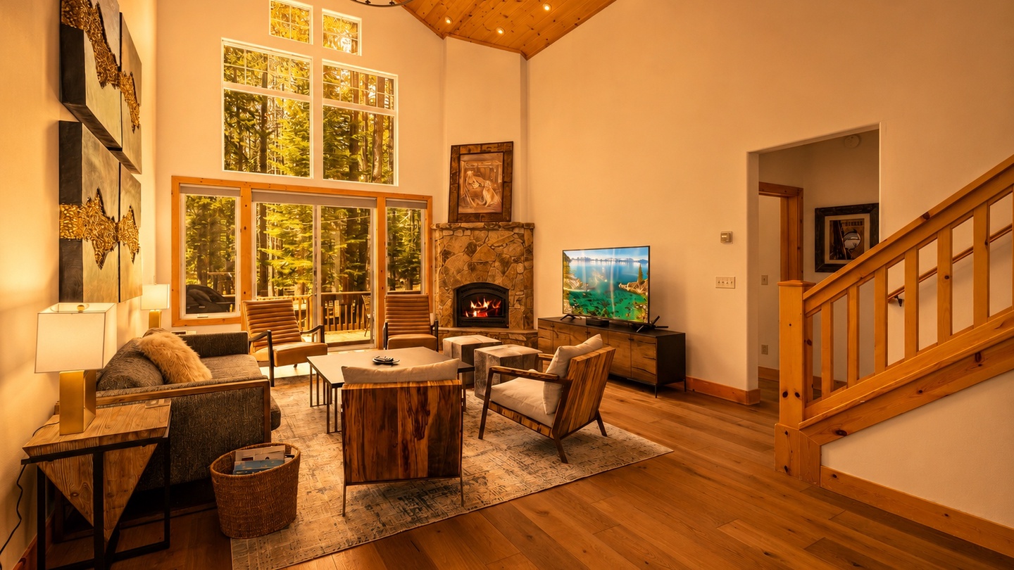 Step into your inviting living space where soaring ceilings, warm wood tones, and floor-to-ceiling windows frame forest views. Cozy up by the stone fireplace or relax on comfortable seating as natural light fills every corner.