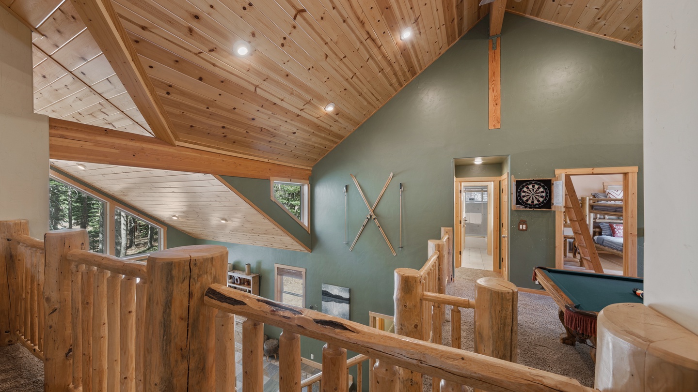 Step into your alpine retreat, where soaring wood-beamed ceilings and soft natural light create a warm, inviting atmosphere. A dartboard and billiards await your friendly competitions in this spacious mountain hideaway.