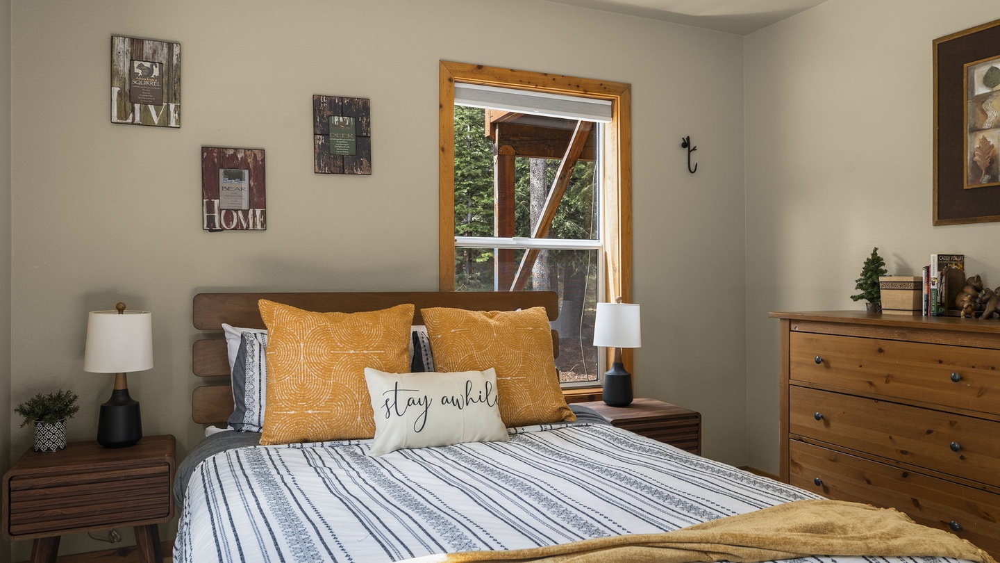 Sink into crisp linens and golden accents in your cozy retreat, where warm wood furnishings and thoughtful touches create the perfect home base.