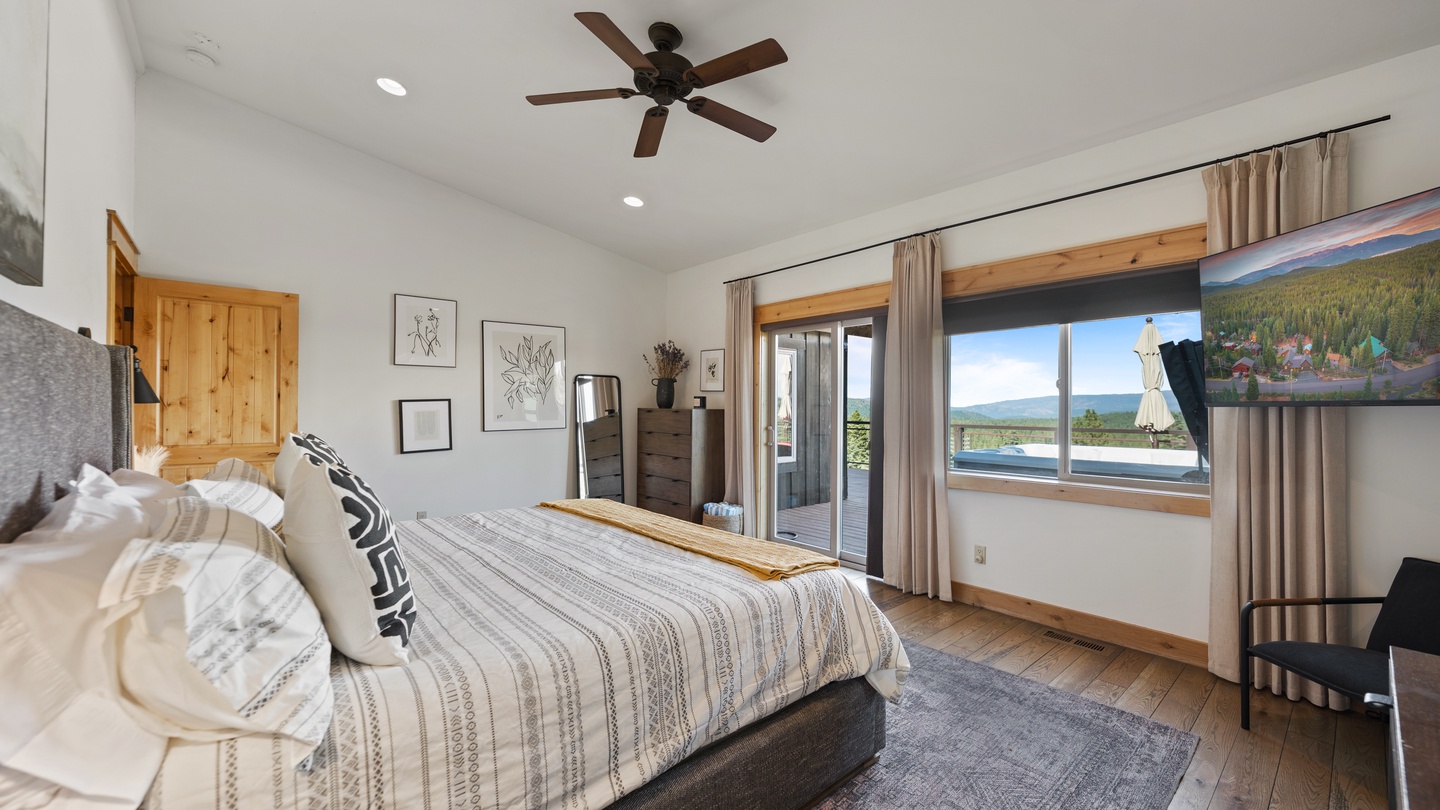 Unwind in your bright, airy bedroom where natural wood accents and soft linens invite restful sleep. Step through the glass door to your private balcony overlooking tranquil water and mountain scenery—your personal escape awaits.