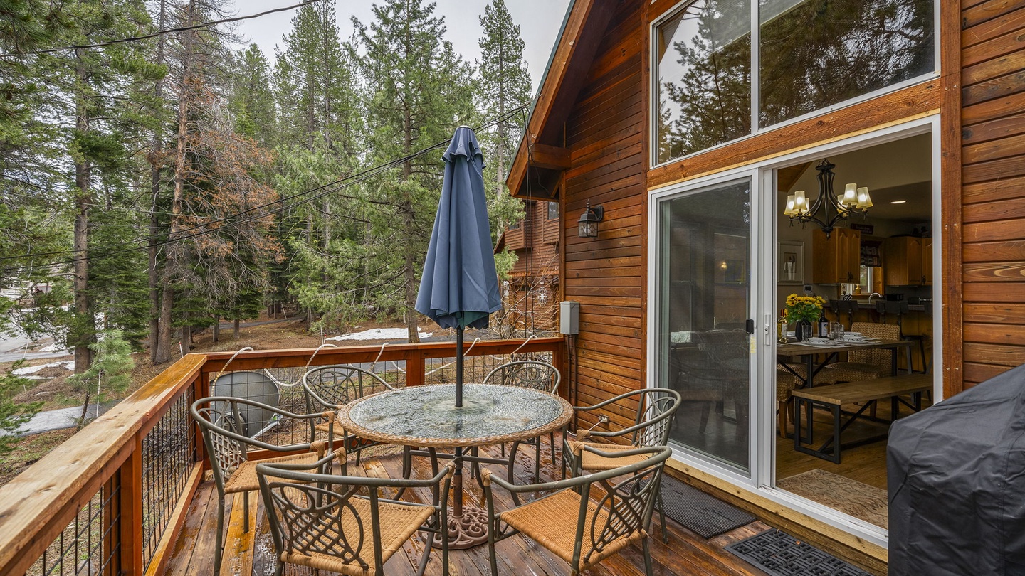 Unwind on your private deck with forest views, outdoor dining table, and umbrella shade for perfect al fresco meals.