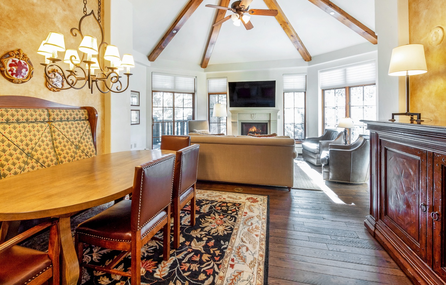 Elegant wood-beamed ceilings crown your spacious retreat, where rich hardwood floors and a glowing fireplace create a warm, inviting atmosphere perfect for relaxing after a day's adventure.