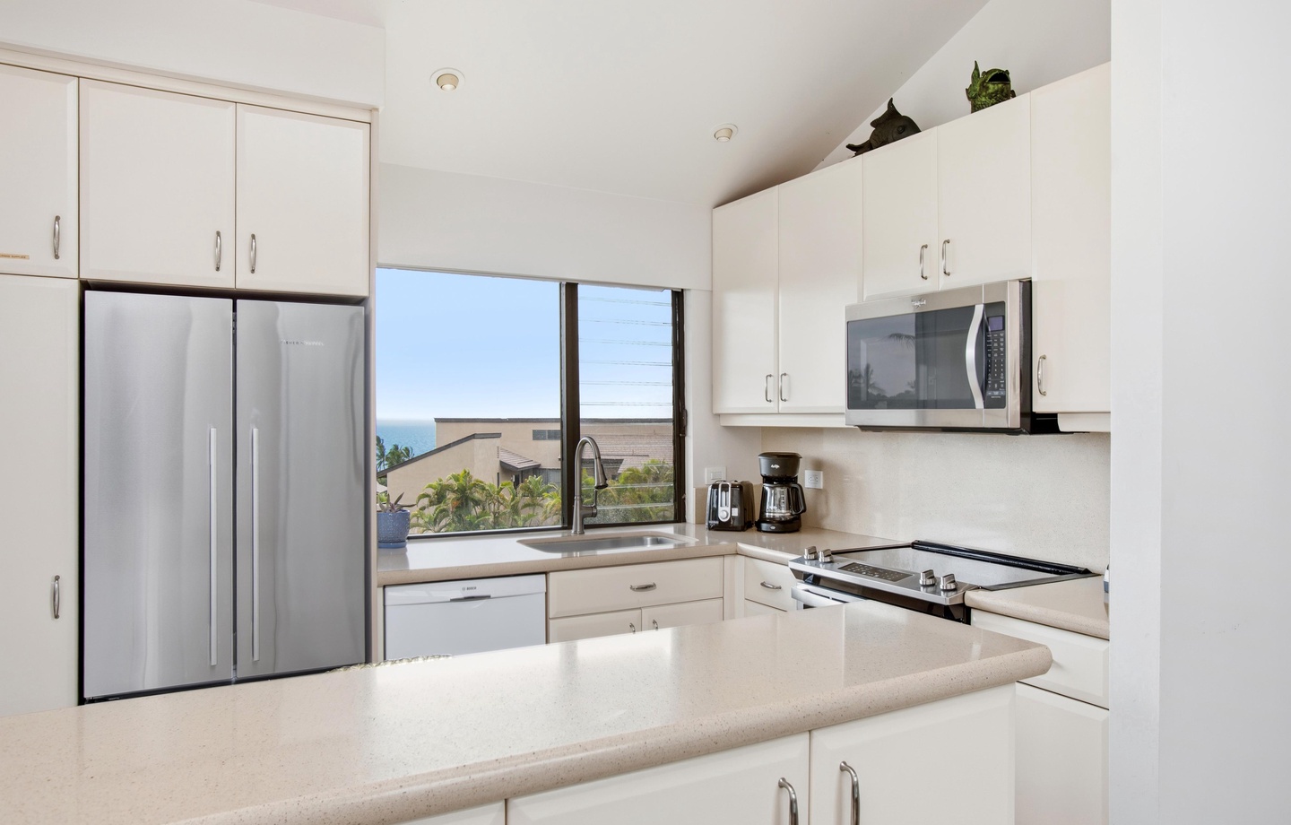 Your bright, modern kitchen comes fully equipped with sleek appliances and everything you need to prepare meals. The window frames a lovely glimpse of the surrounding area.