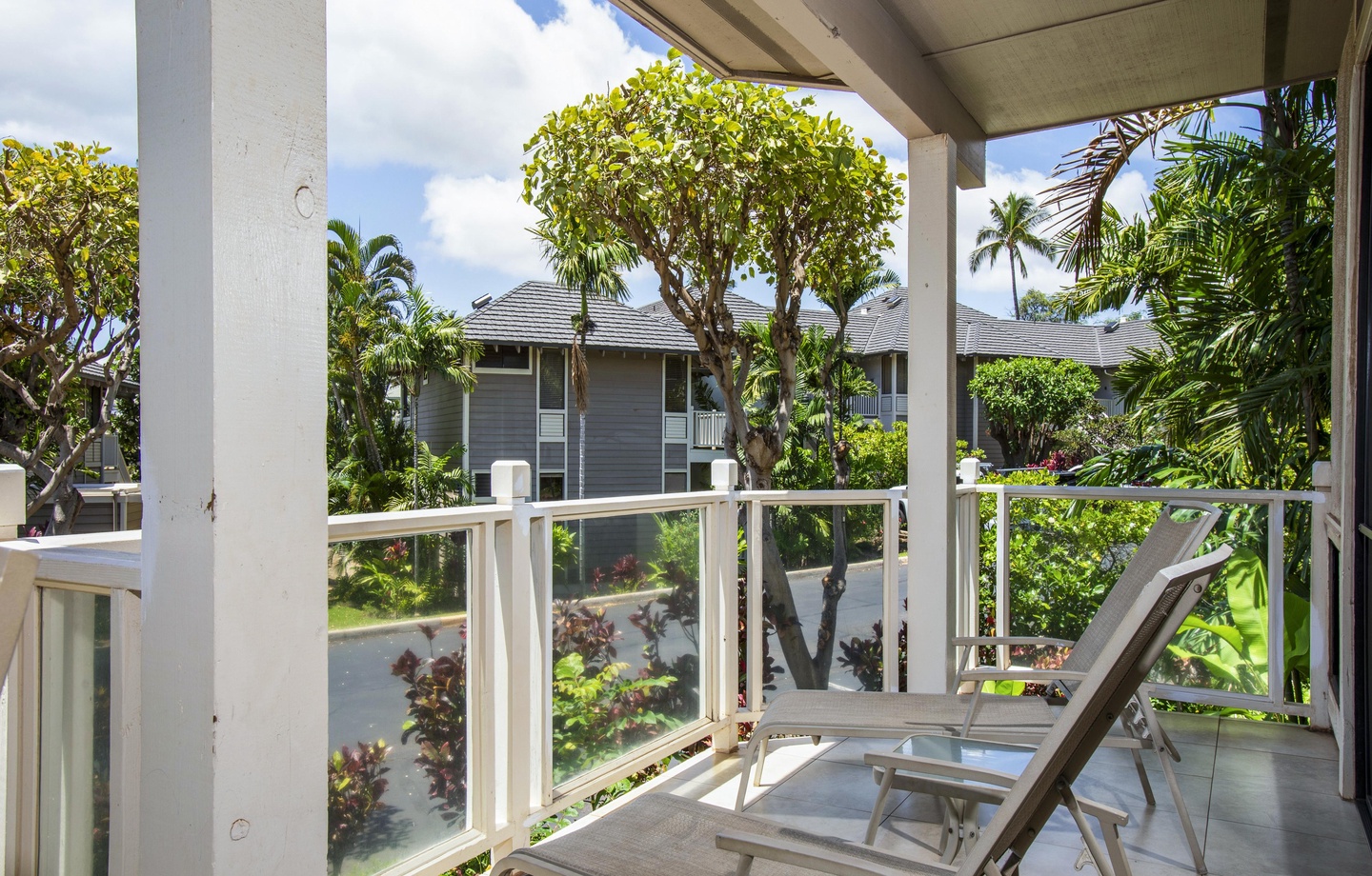 Your private lanai overlooks lush tropical greenery and neighboring resort buildings. Recline on a cushioned lounge chair, feel the island breeze, and enjoy your peaceful outdoor retreat.