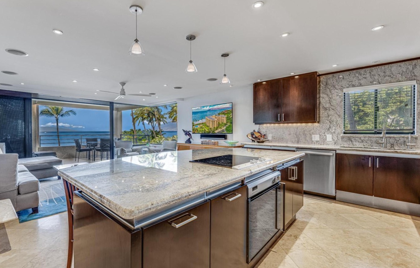 Unwind in a spacious open-concept living area featuring elegant marble flooring, comfortable seating, and oceanfront views through floor-to-ceiing glass walls.