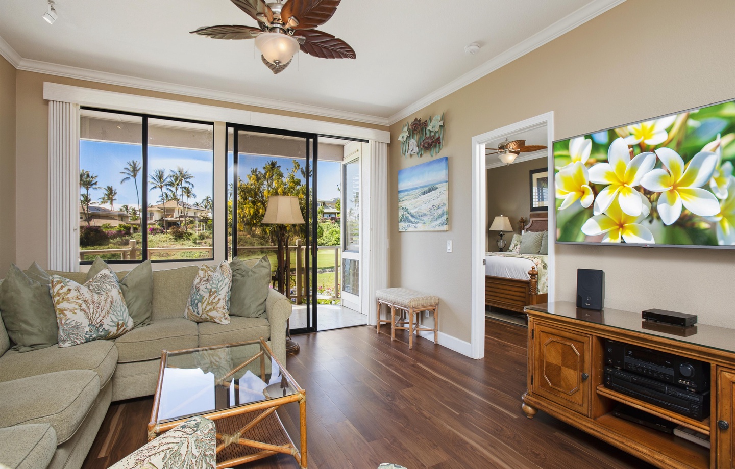 Sink into the plush tropical-themed living room where palm tree views drift in through sliding doors and gentle island breezes invite you to relax completely.