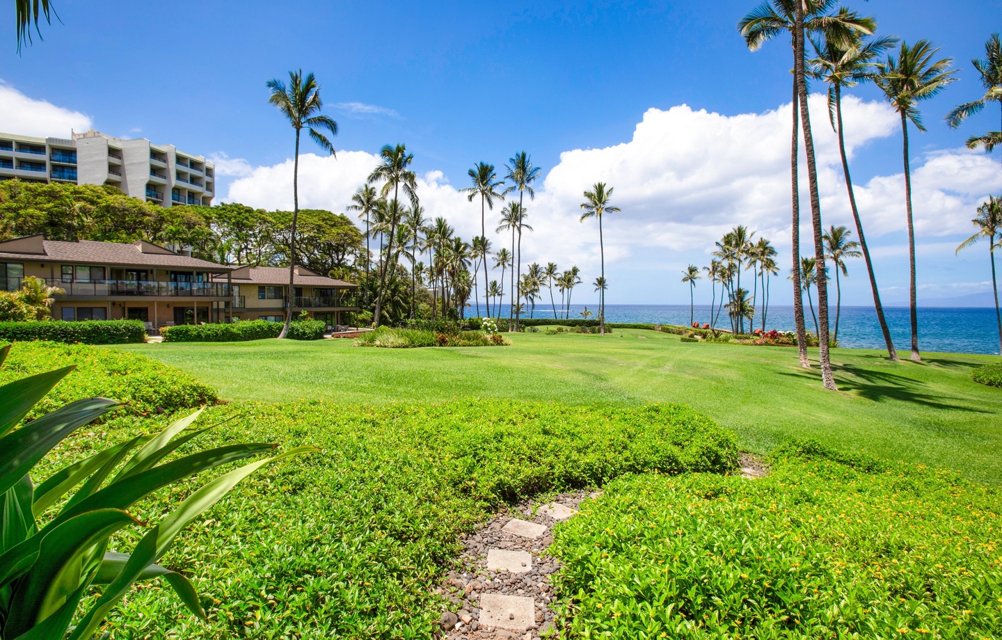 Step straight from your ground-floor lanai onto soft green lawns sweeping toward the ocean at Wailea Elua Village 1603