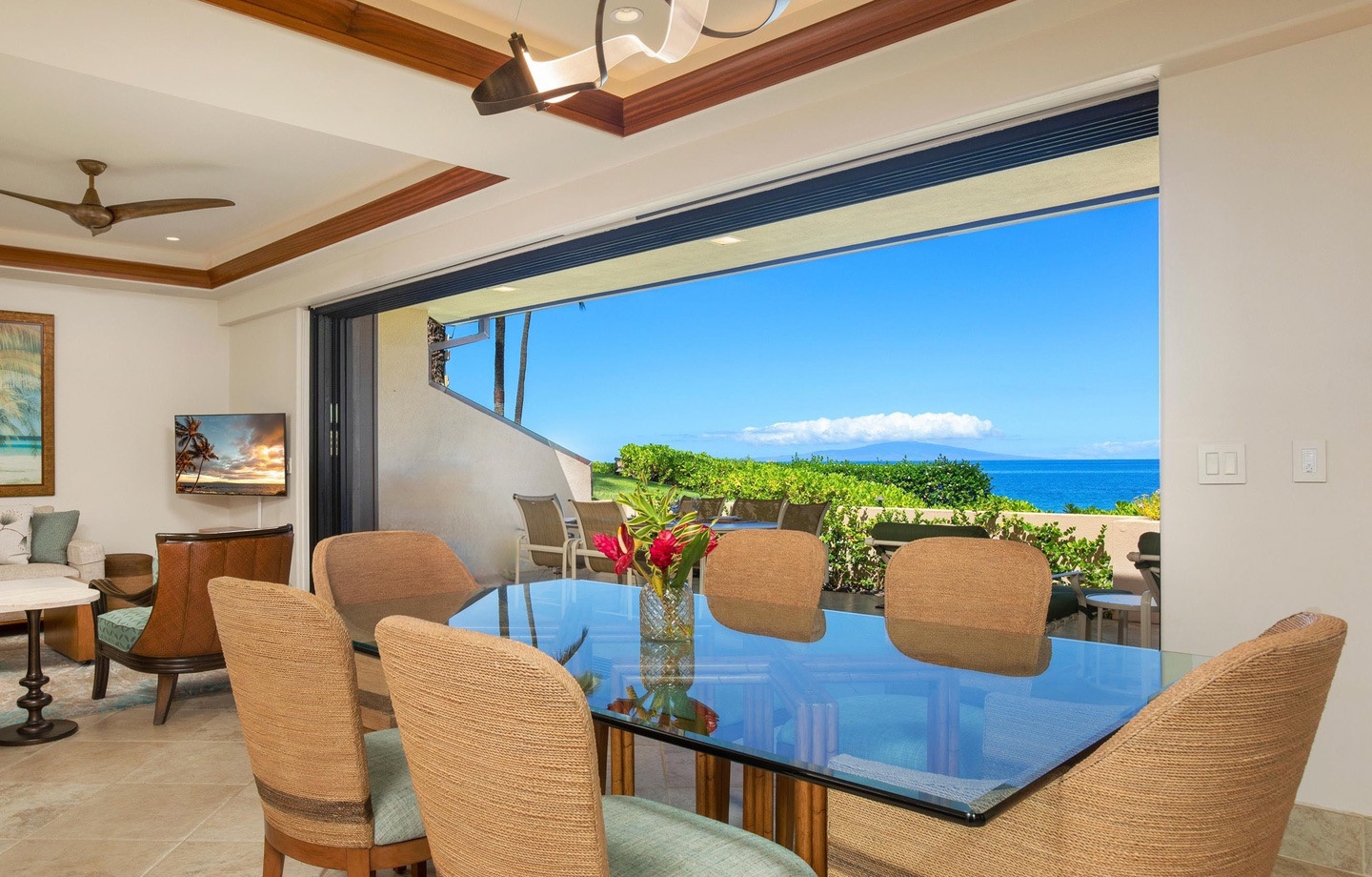 Gather with loved ones at this stunning dining table where fresh tropical blooms meet breathtaking ocean views. You'll savor every meal with the sparkling blue water as your backdrop.