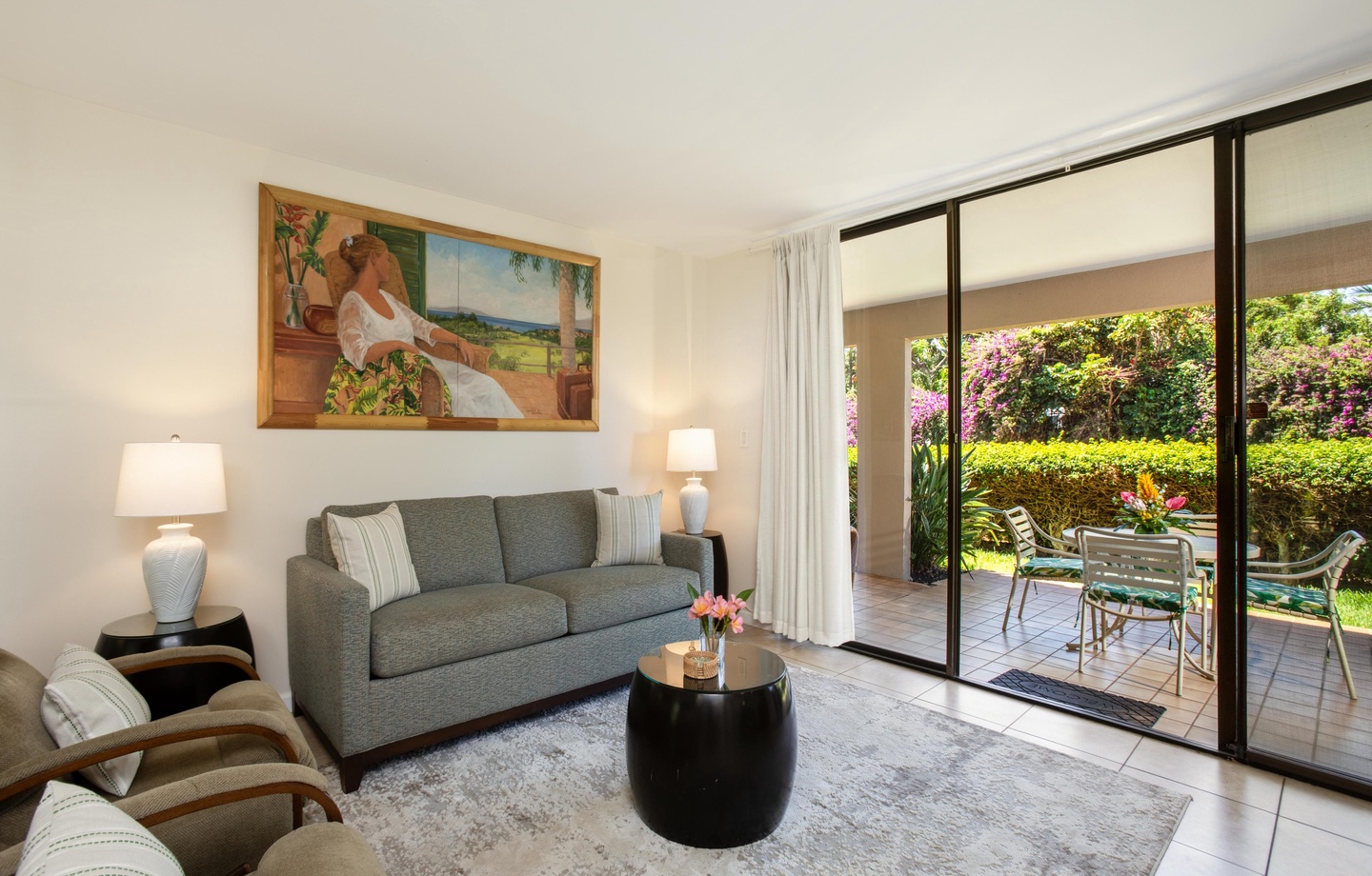 Unwind in your bright living room, where sliding doors open to a private patio with garden views. Fresh flowers, plush seating, and natural light create the perfect retreat after exploring the island.