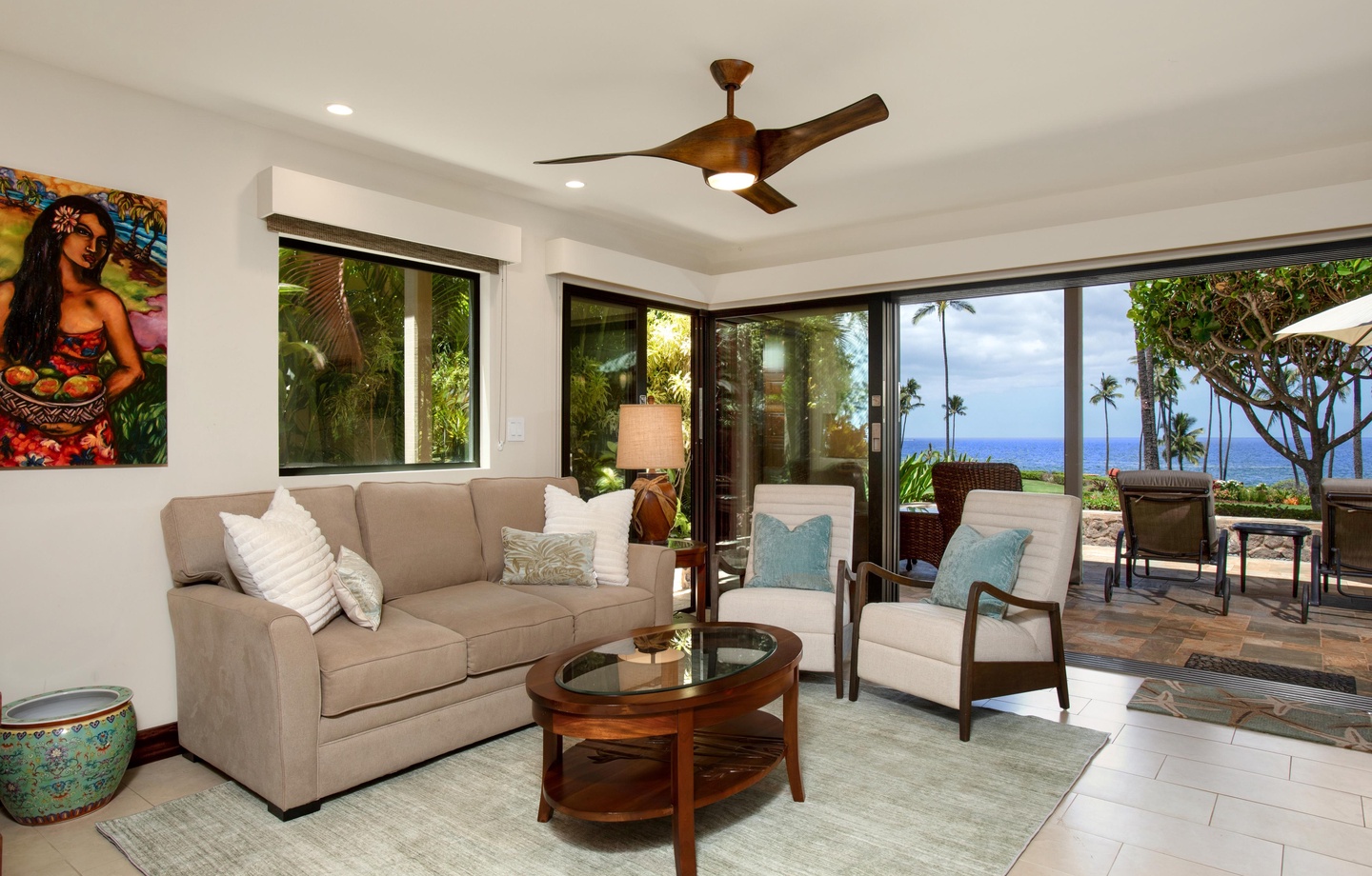 Sink into comfort on the plush seating and let the tropical breeze drift in. Through the open lanai, palm trees frame a stunning ocean view that's all yours to enjoy.