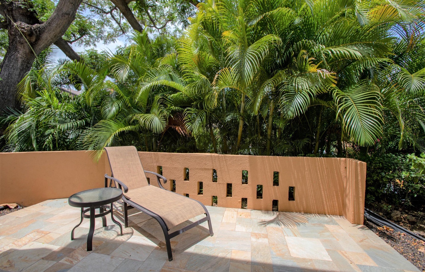 A private outdoor patio and secluded bedroom lanai offering a peaceful tropical garden setting for morning coffee or evening unwinding.