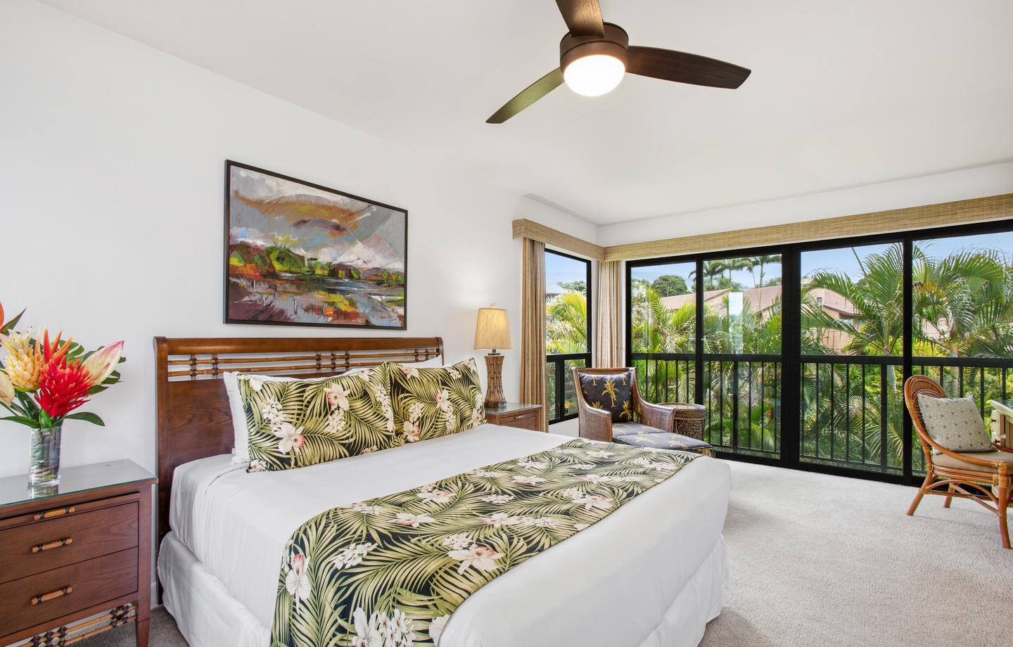 Drift off in your tropical-themed bedroom, where crisp white linens meet lush palm prints and a ceiling fan whispers overhead. Wake to views of swaying palms framed by your private balcony.