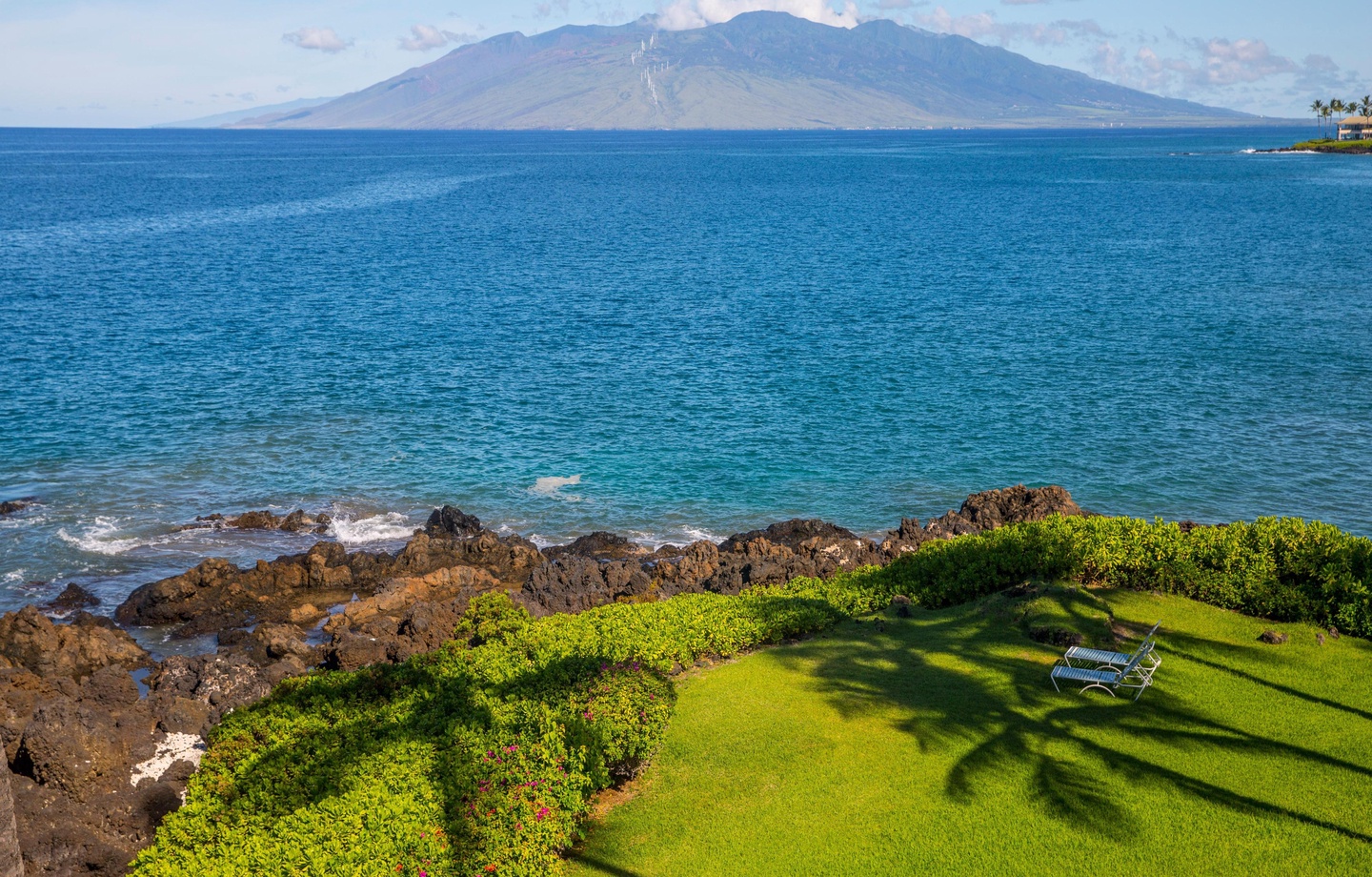 Perched on the top floor, this 1,035 sq.ft. 2-bedroom oceanfront sanctuary features an expansive lanai with panoramic Pacific views over a vibrant reef.