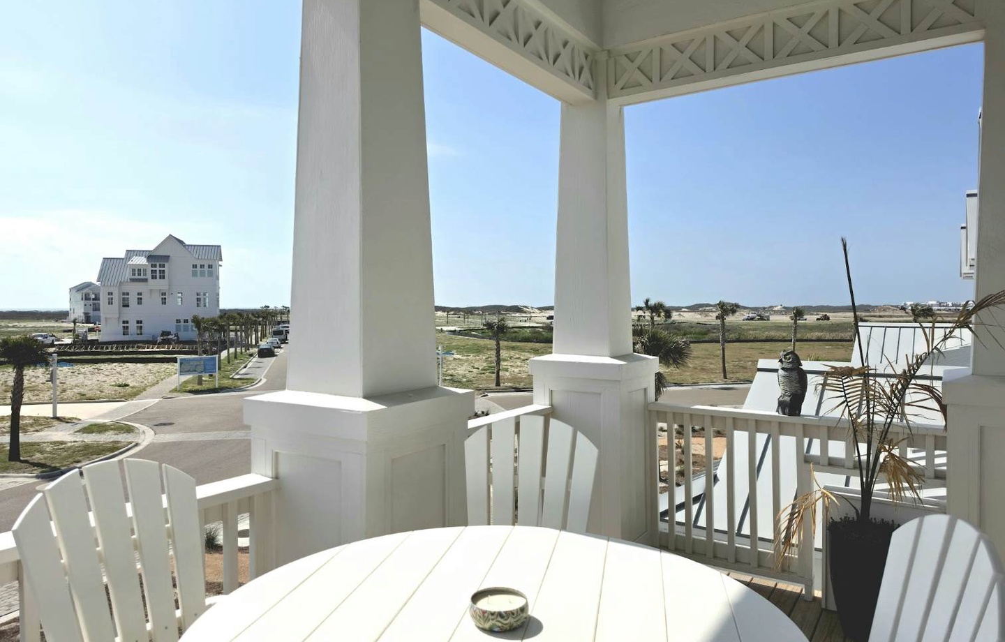 A covered porch overlooking the surrounding neighborhood, offering a peaceful spot to enjoy your morning coffee or evening breeze in the coastal setting.