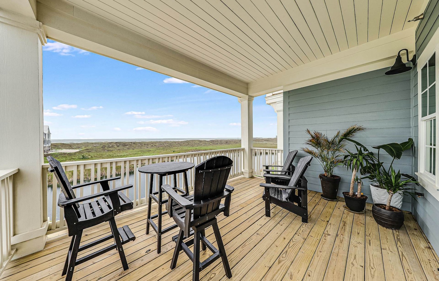 Settle into your private covered balcony with comfortable seating and sweeping views of coastal marshlands stretching to the horizon—your peaceful retreat awaits.