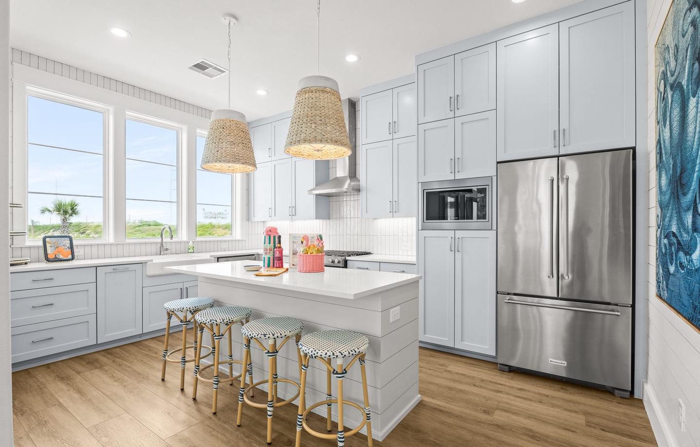 Cook your favorite meals in this bright, fully equipped kitchen with stainless steel appliances, ample counter space, and natural light streaming through large windows.