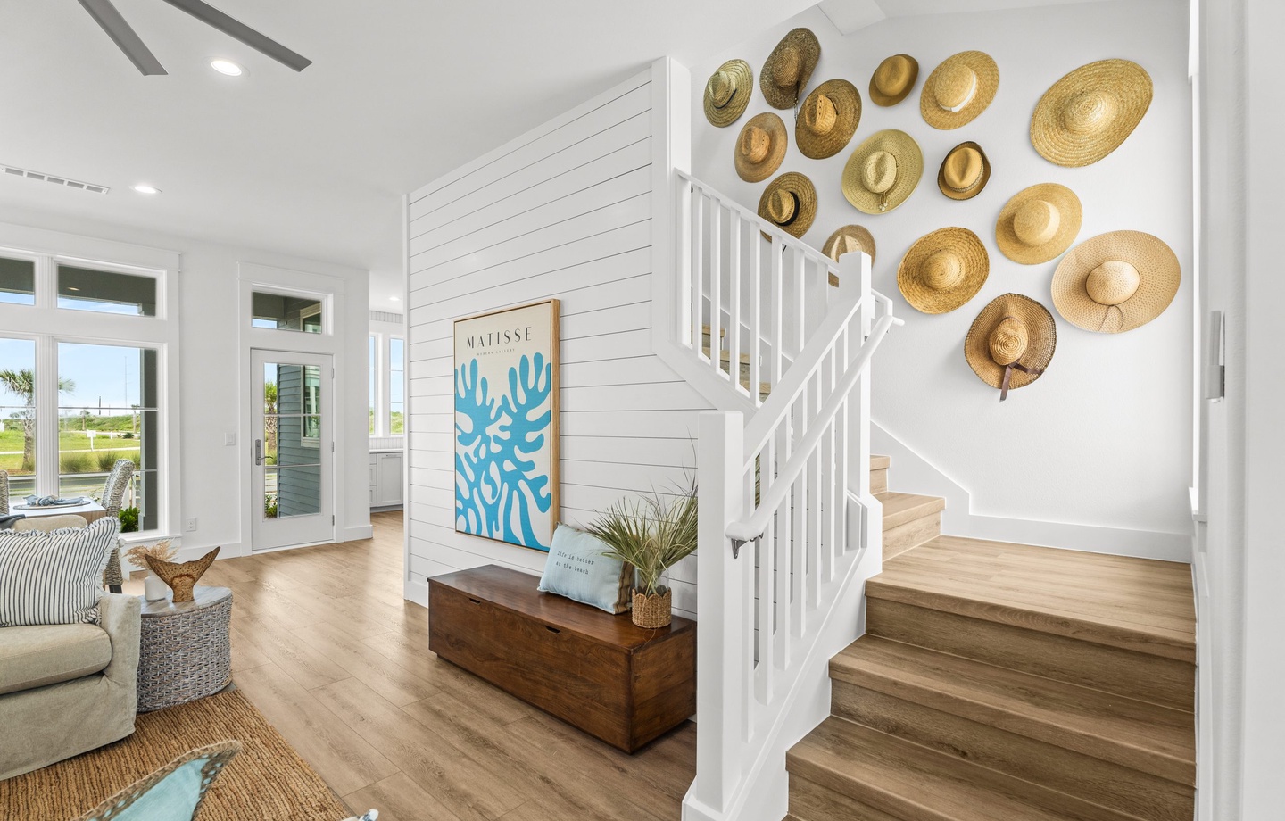 Step into your bright, coastal retreat where natural light floods through large windows, warm wood floors guide you upstairs, and beach-inspired touches invite you to unwind in style.
