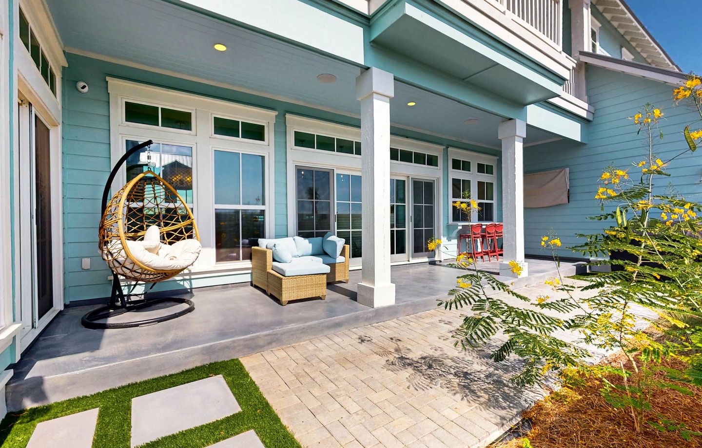 The property features coastal-style architecture with a spacious, covered patio designed for relaxation and outdoor living.