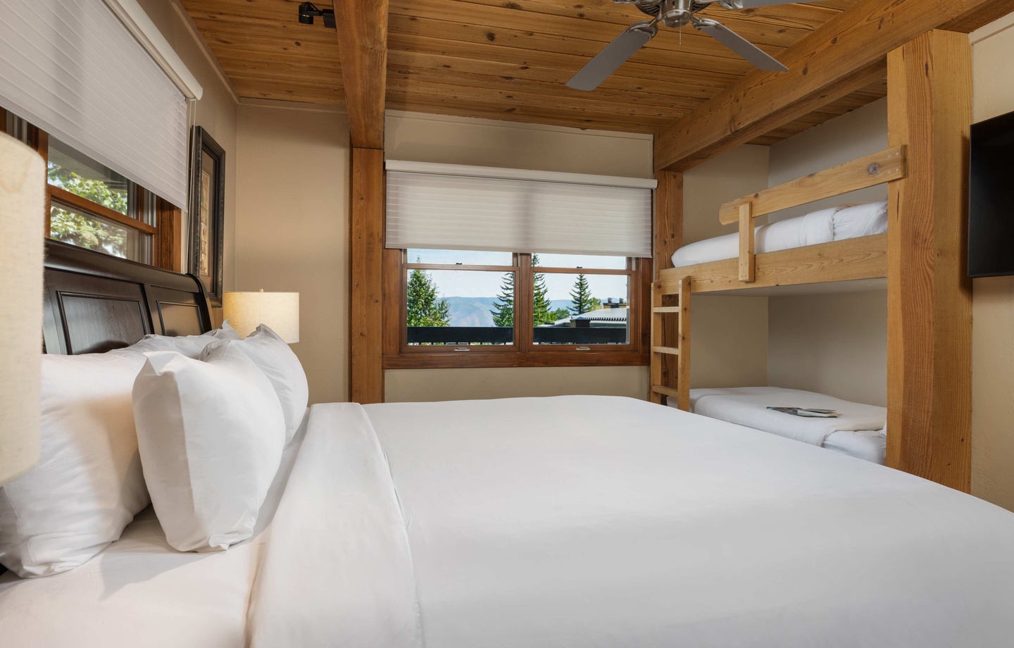 Sleep soundly in your cozy retreat with handcrafted wooden beams overhead and mountain views peeking through your window. The inviting bed and bunk setup makes this the perfect space for families or friends.