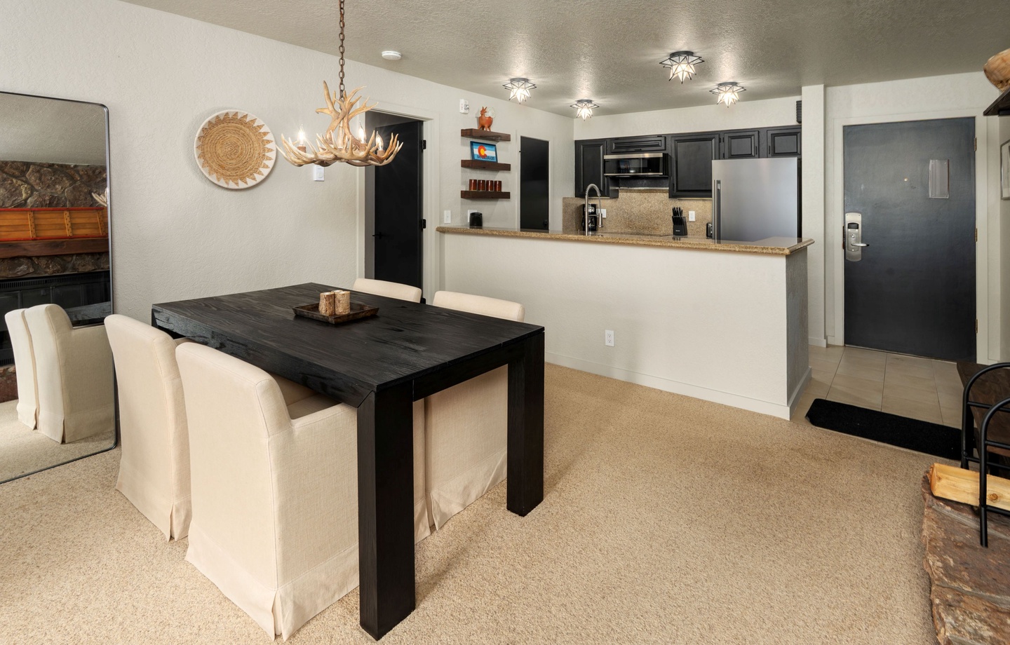 Gather around the elegant dining table for meals, with the fully equipped kitchen right at your fingertips. The rustic chandelier and cozy fireplace create a warm, inviting atmosphere for memorable evenings.