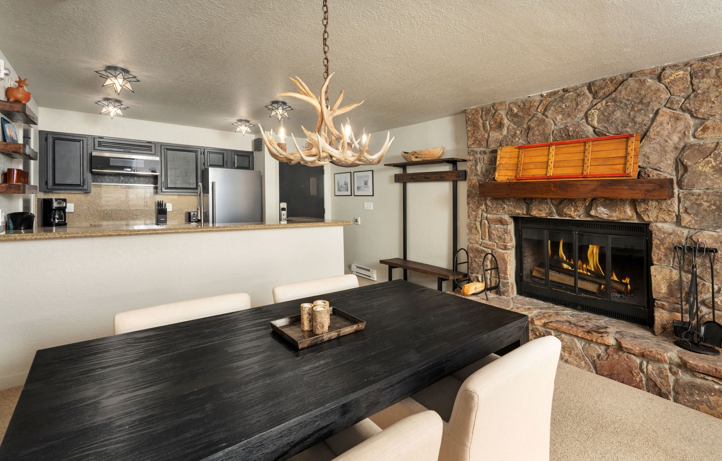Gather around the rustic antler chandelier and crackling fireplace, where your mountain getaway memories will be made over home-cooked meals in this inviting open-concept space.