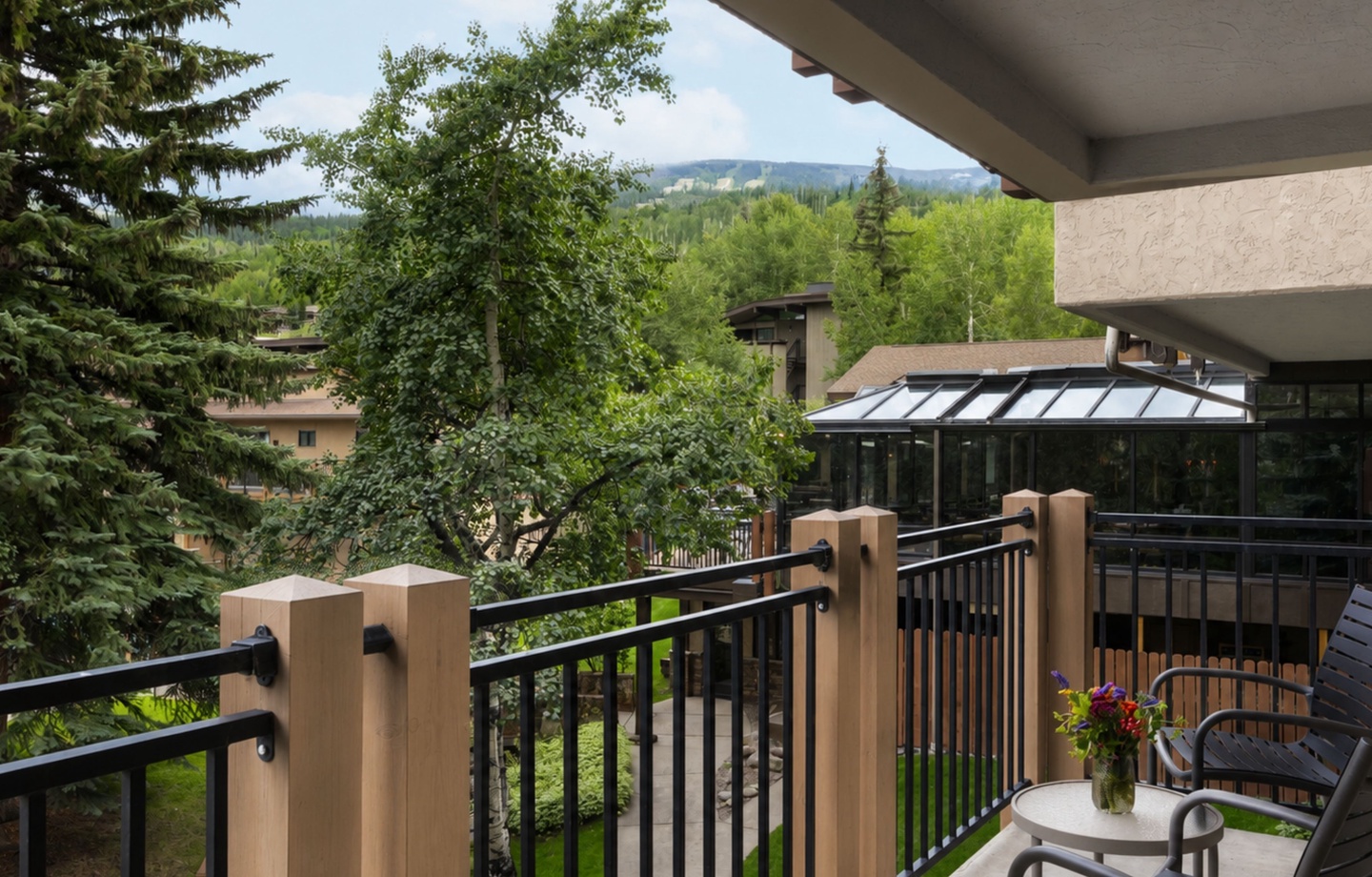 Sip your morning coffee on this private balcony surrounded by lush evergreens and rolling mountain views—your peaceful alpine retreat awaits.
