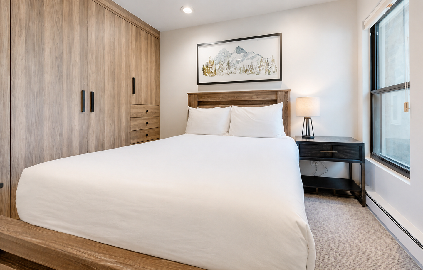 Slip into crisp white linens and rest easy in your cozy bedroom, thoughtfully designed with warm wood tones and all the comforts you need for a peaceful mountain retreat.