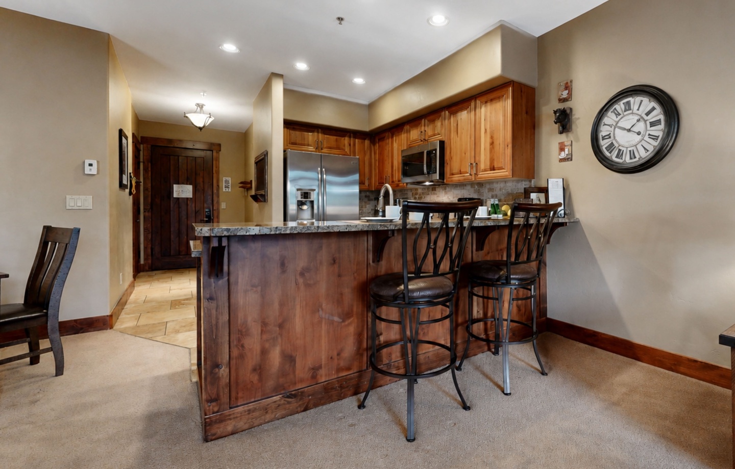 Step into your fully equipped kitchen with granite countertops, rich wood cabinetry, and stainless steel appliances. Gather around the island with seating for casual meals and morning coffee.