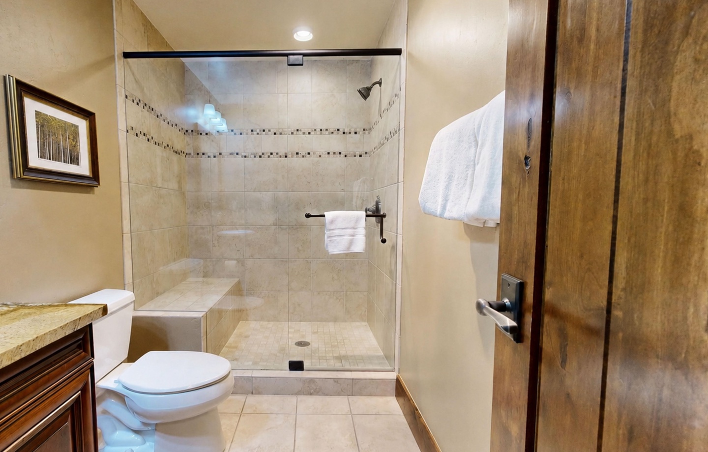 Step into your private spa-like bathroom with a spacious walk-in shower featuring elegant tile work and a built-in bench for ultimate comfort.